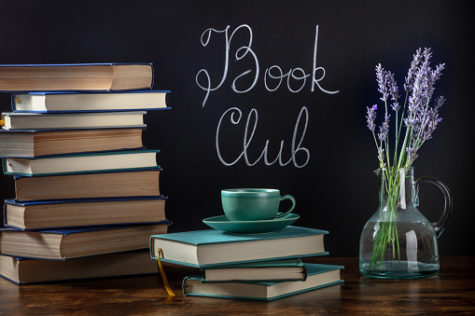 Book Club Concept. A stack of books and coffee on a desk with chalk lettering on a blackboard and lavender flowers