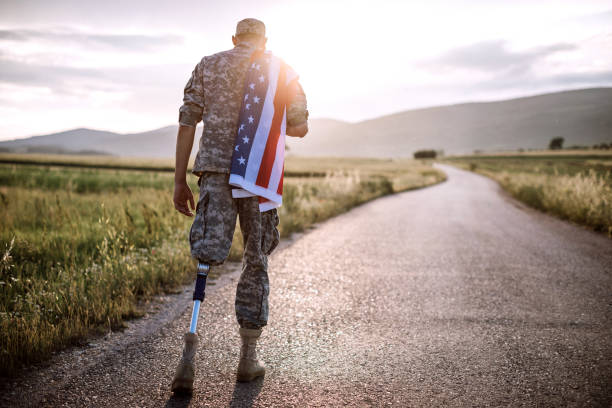 Rear+View+Of+Young+Amputee+Soldier+Walking+Road+Wearing+American+Flag