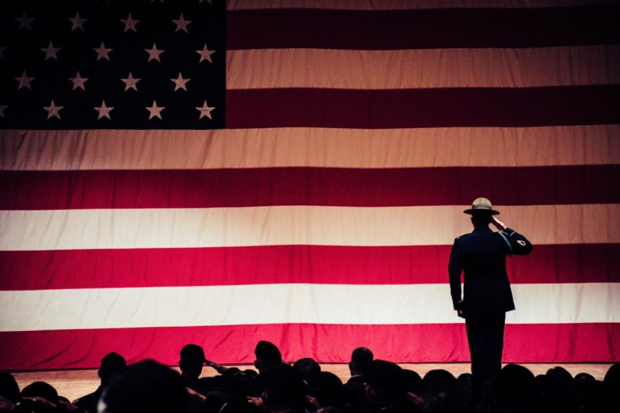 A shadowed American flag with a soldier saluting to the audience. 