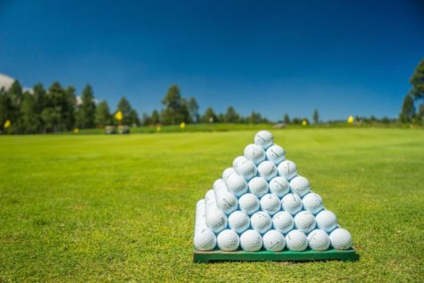 A pyramid of golf balls stacked up on the driving range