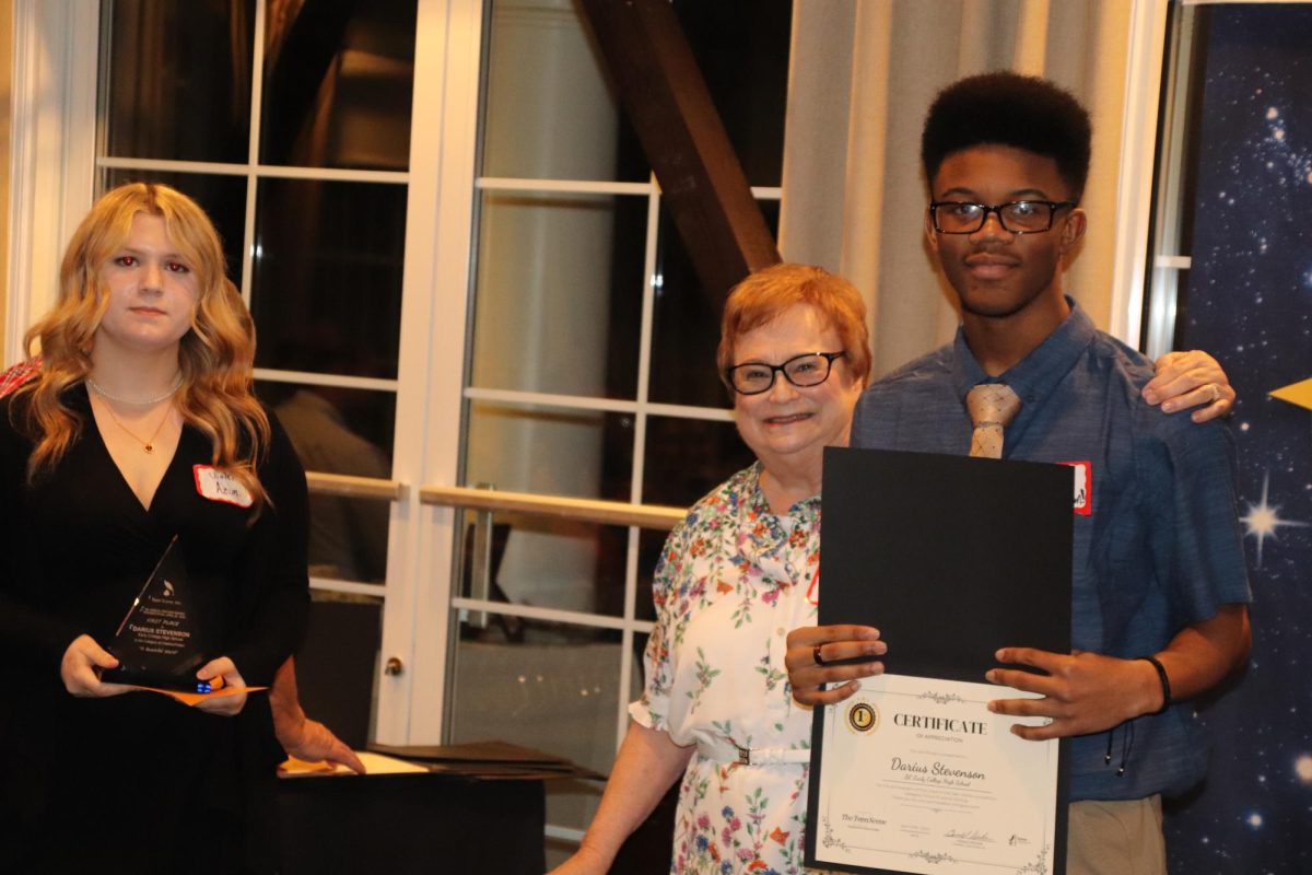 Teen Scene Assistant, Violet Azimi, holds the trophy for Darius Stevenson, which was presented by Pat Batleman