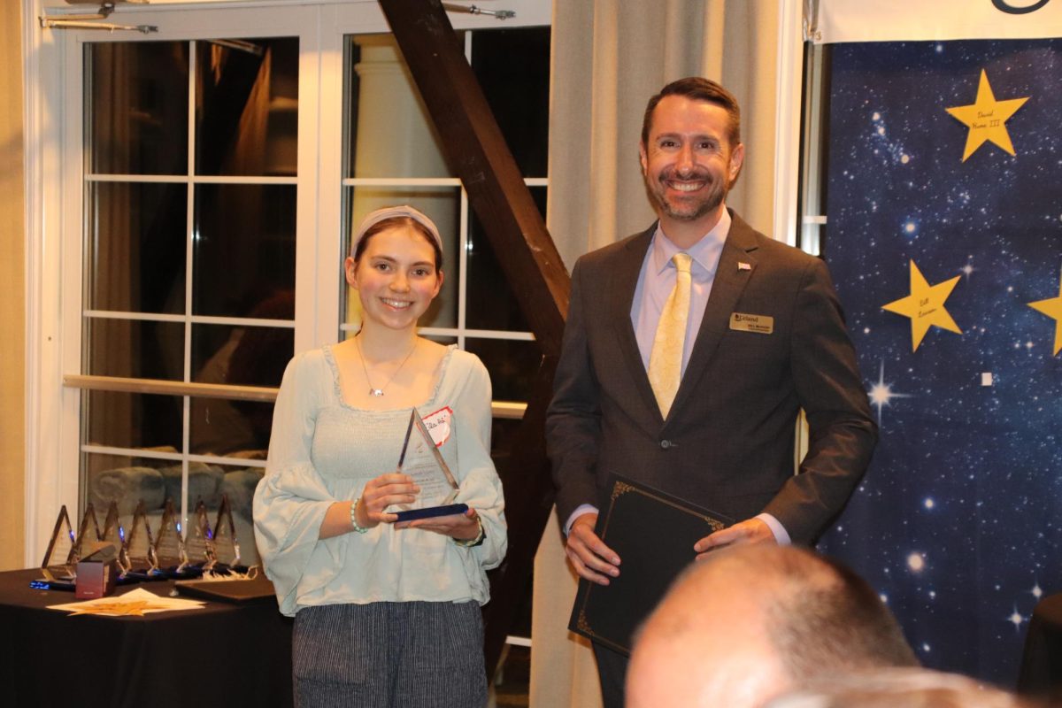 Eila Adair accepts her trophy from Councilman Bill McHugh in the category of Persuasive Essay