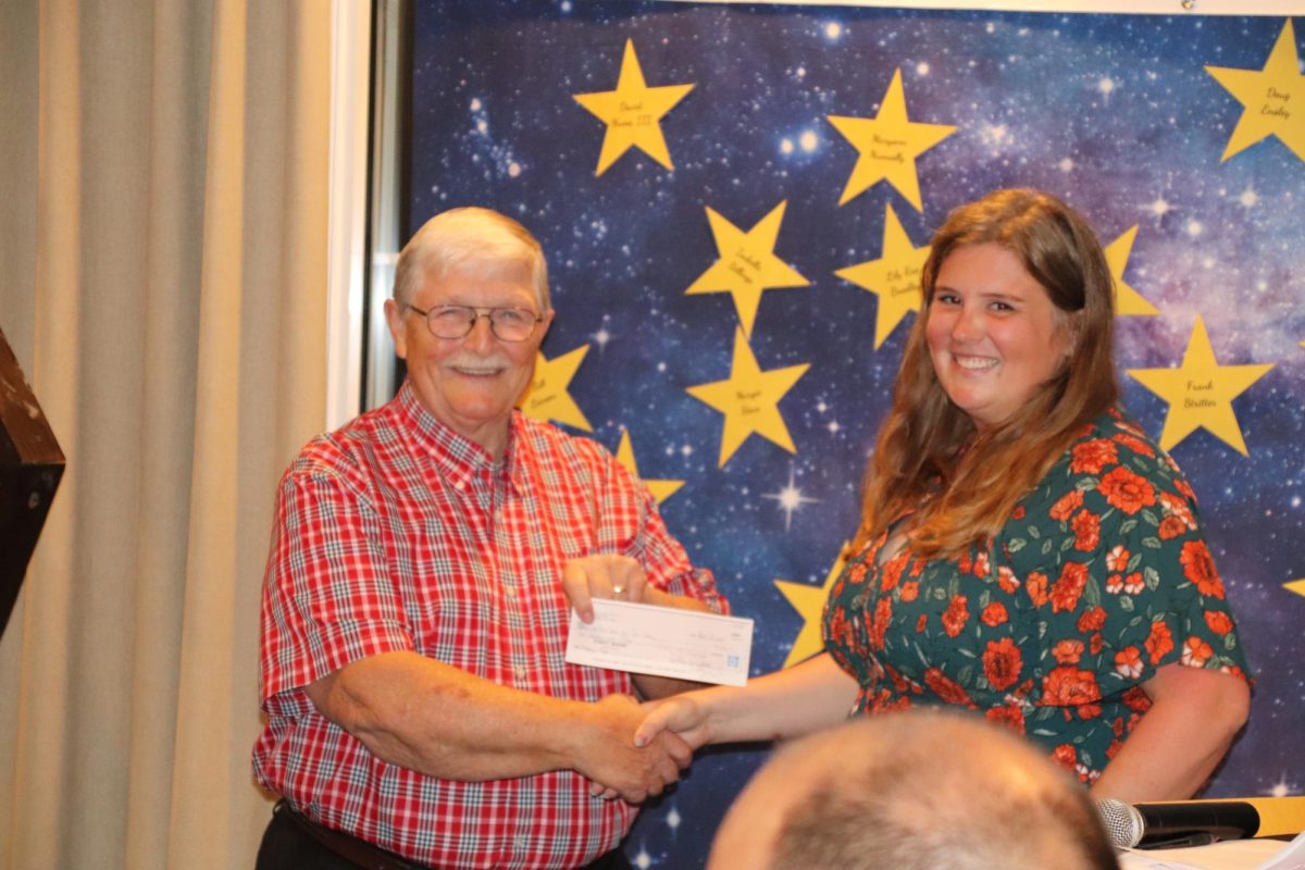 Gerald Decker accepts a check from the Brunswick Arts Council presented by their president, Sydnee Moore